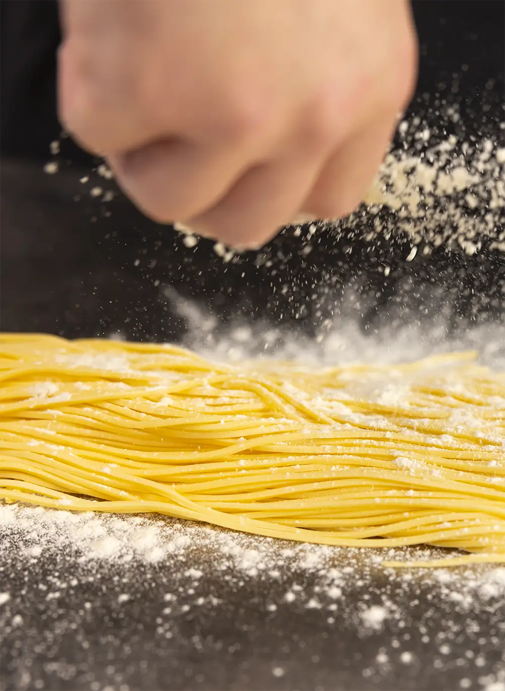 cloud of flour on homemade pasta